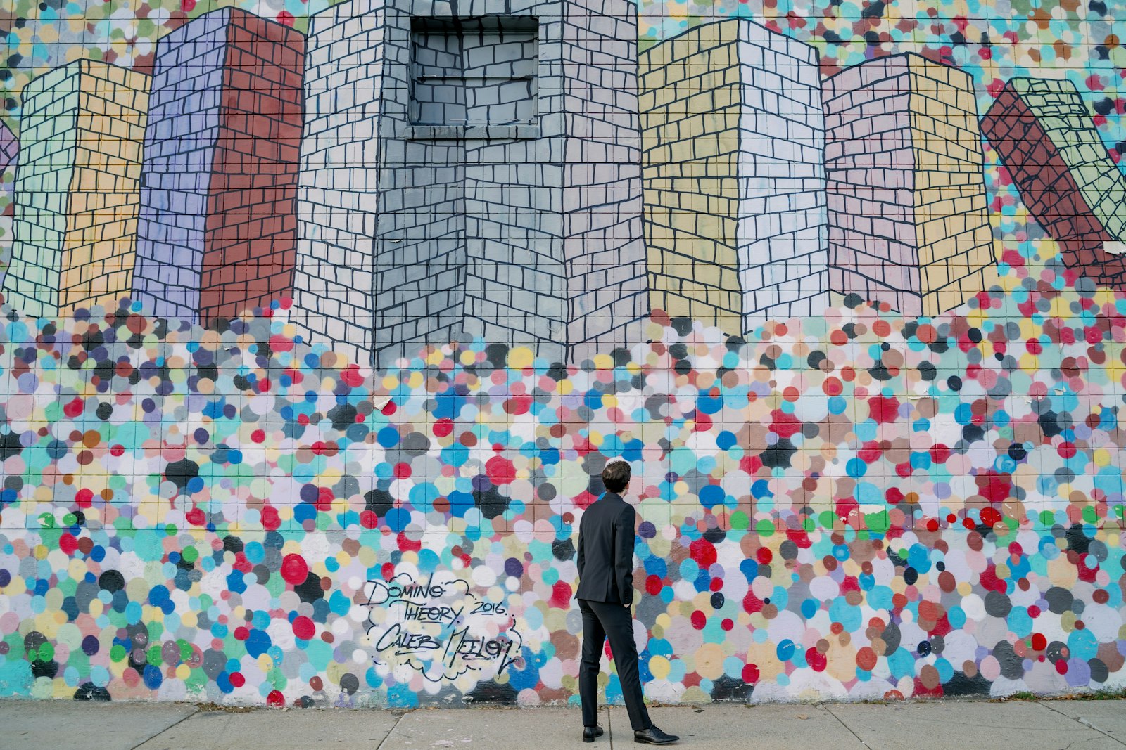 Sony a7 III + Samyang AF 35mm F1.4 FE sample photo. Man standing beside multicolored photography