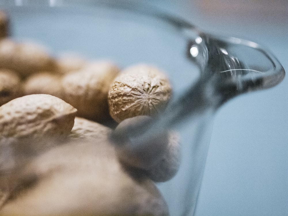 close-up photography of peanuts in clear glass bowl