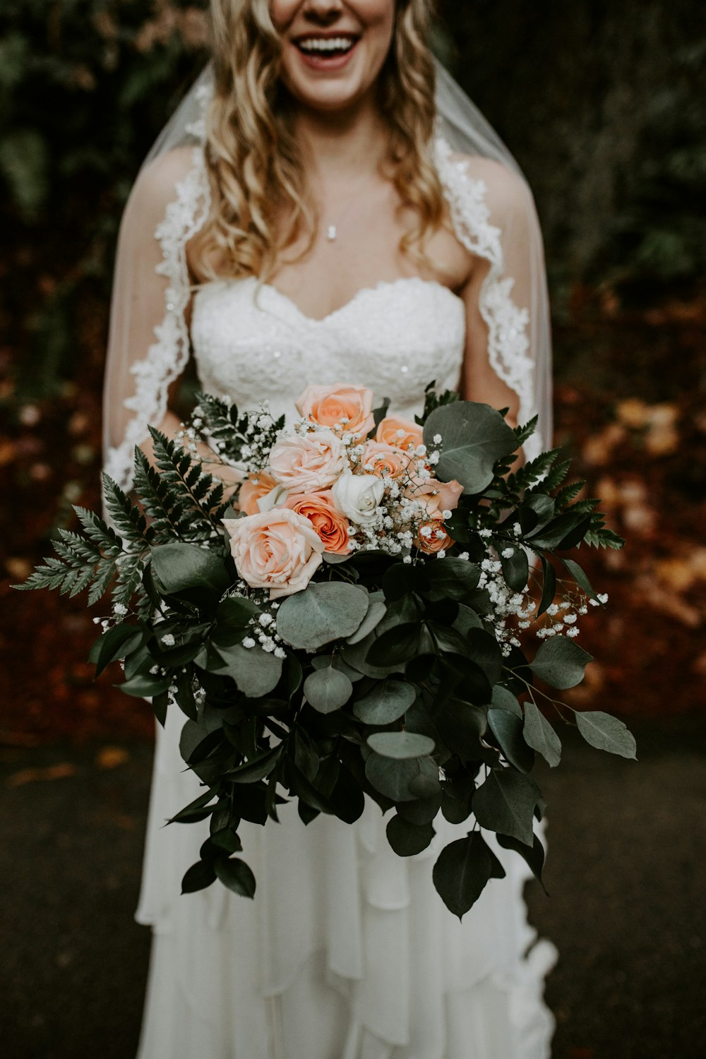 woman wearing wedding gown holding rose bouquet