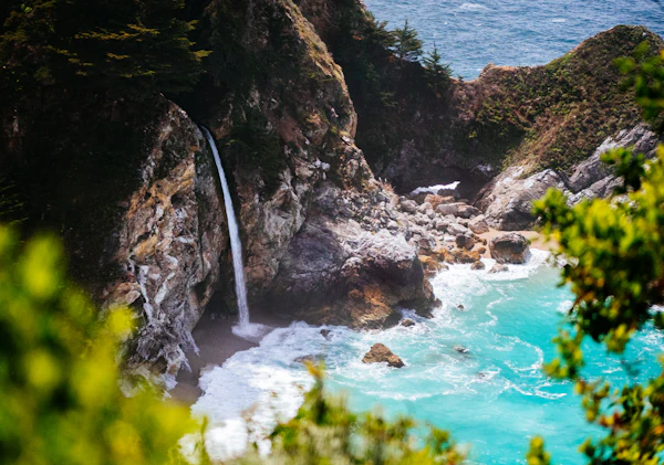 McWay Falls waterfall dropping onto the beach, viewed from roadside pullout
