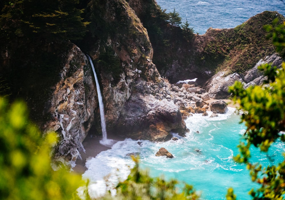 waterfall on cliff near seashore