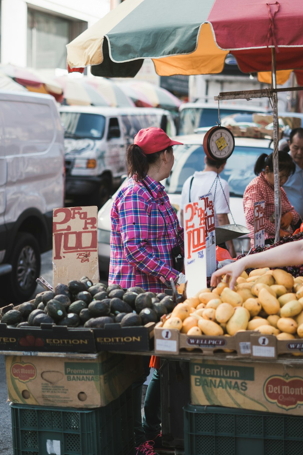 a woman standing in front of a fruit stand