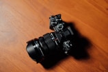 A professional camera resting on a wooden table with natural light highlighting its details