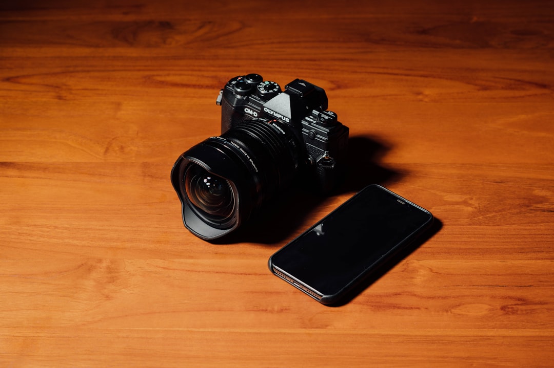 black DSLR camera and black smartphone