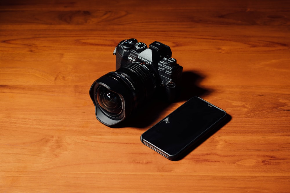 black DSLR camera and black smartphone