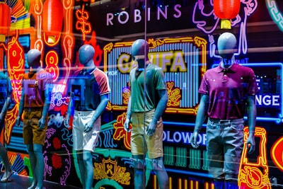 Vibrant clothing items displayed on mannequins against a bright, clean background.