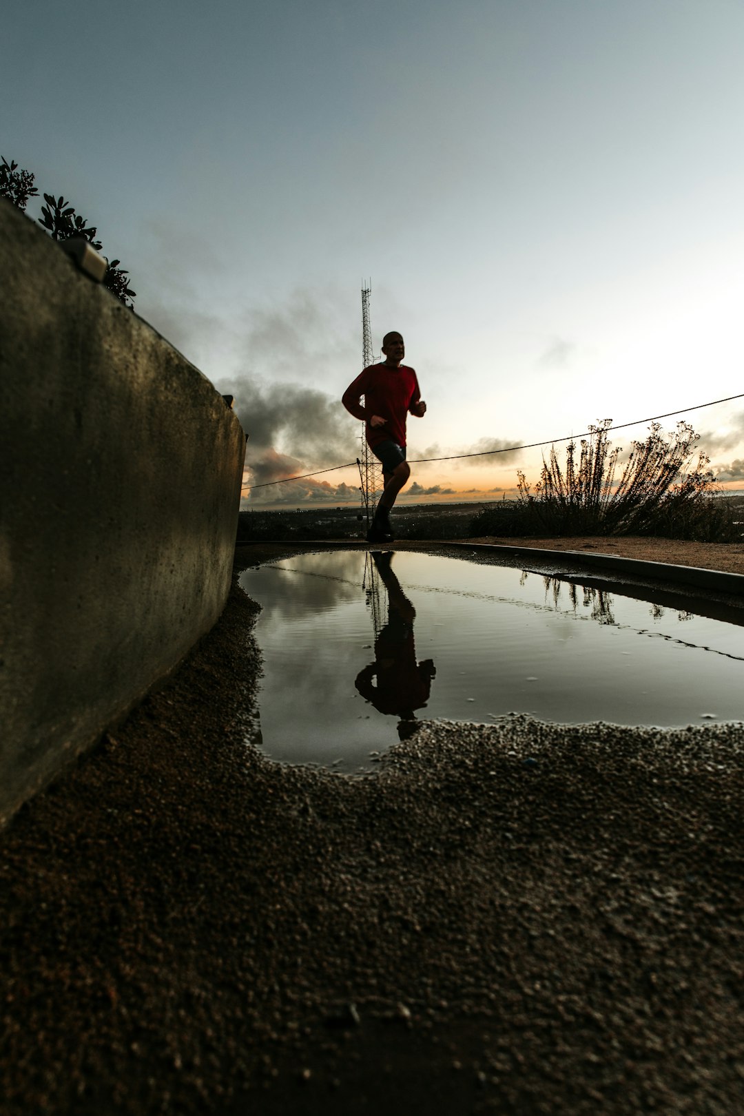 reflection of jogging man on water on road