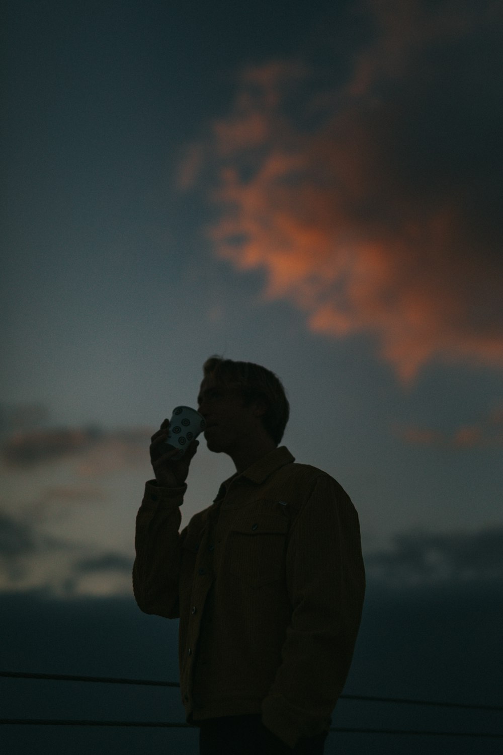 man drinking from cup