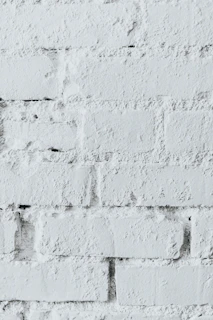 Close-up of hands inspecting the texture and finish of architectural bricks.