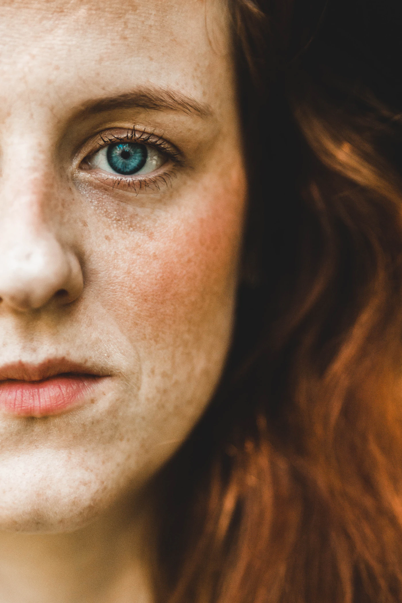 Close-up portrait of a person's cheek and central-face skin, representing the area most commonly affected by facial redness and rosacea-related concerns