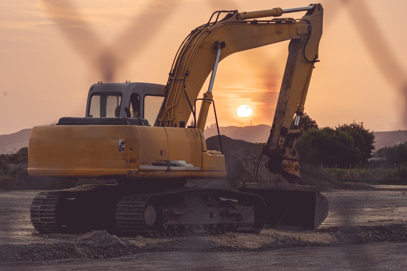 Illustration of a powerful excavator digging at a construction site with a sunset backdrop