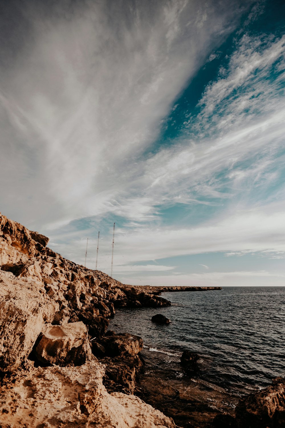 brown rock under white clouds