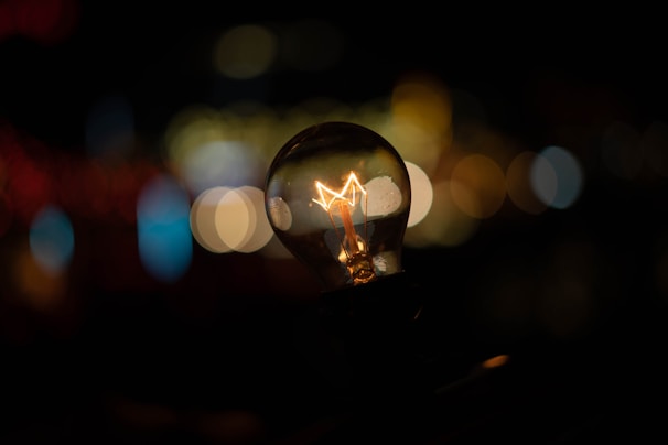 Close-up of a modern smart bulb glowing softly with color-changing capability.