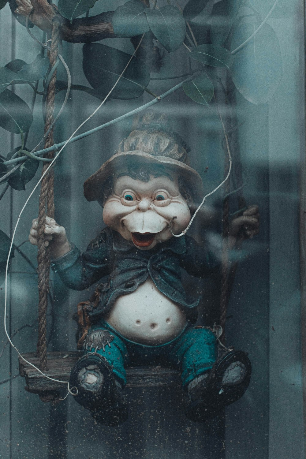 gray and brown monkey sitting on swing figurine