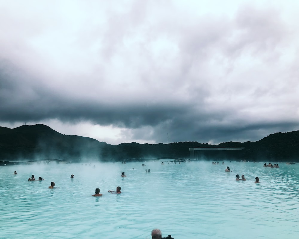 photography of people in body of water during daytime