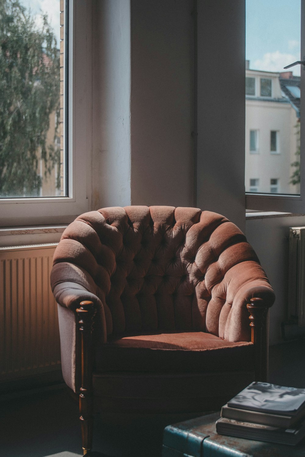 tufted brown suede sofa chair near windows