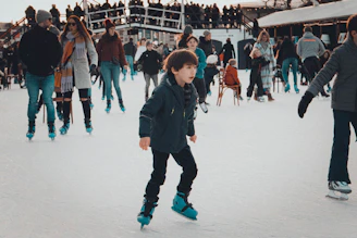 Children and adults learning to skate together in a bright, welcoming rink