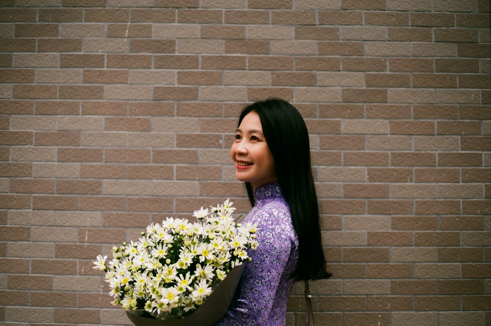smiling woman holding white petaled flower bouquet