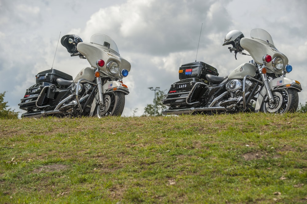 white-and-black touring motorcycles on hill under cloudy sky