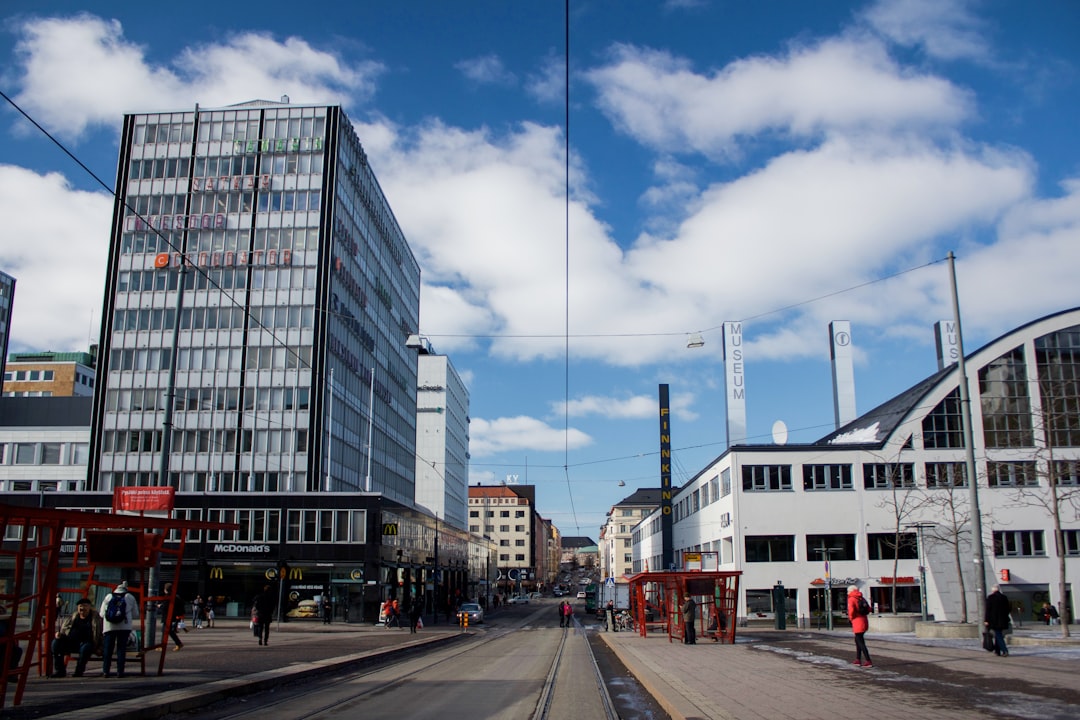 street between buildings under blue cloudy sky