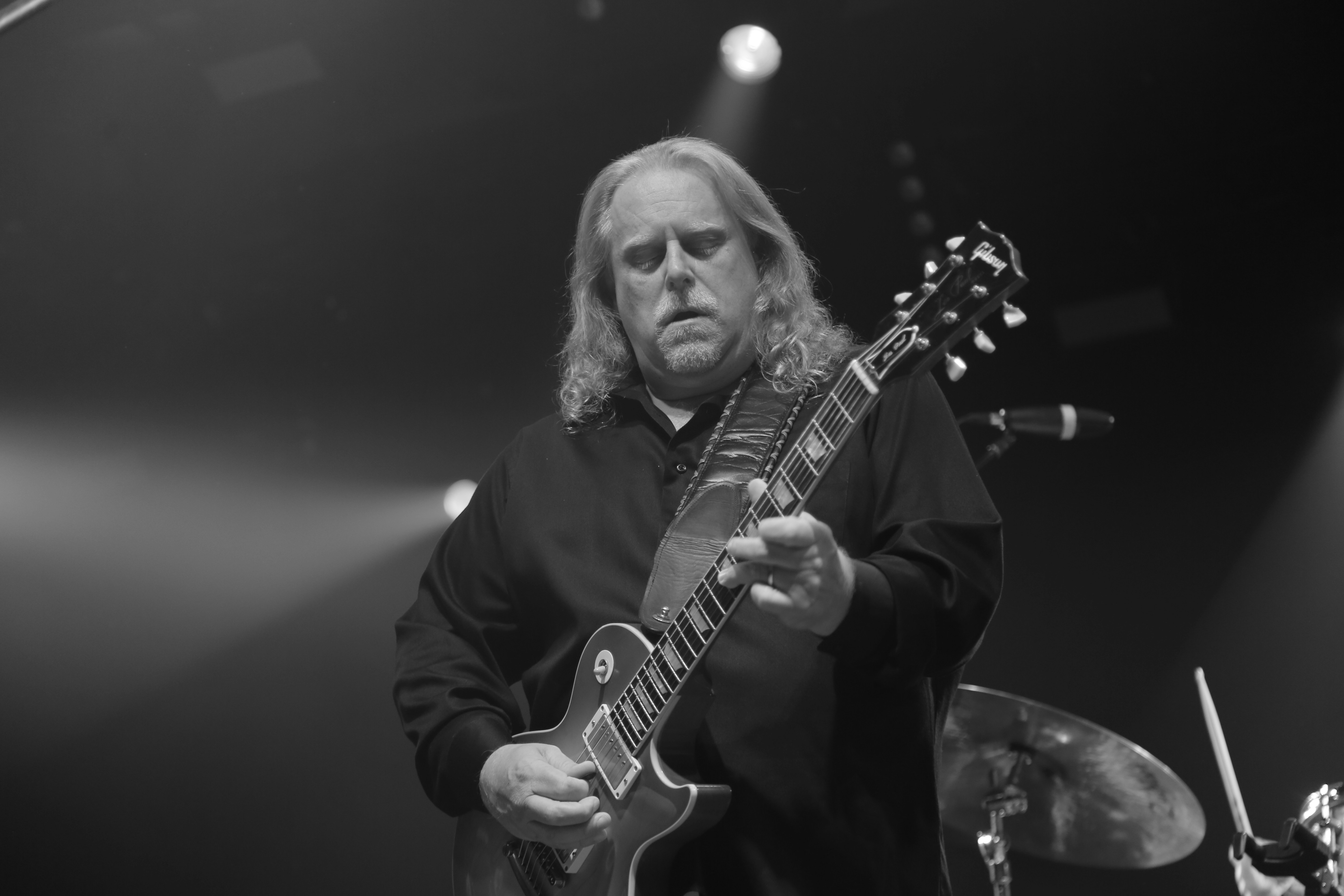 grayscale photo of man playing guitar