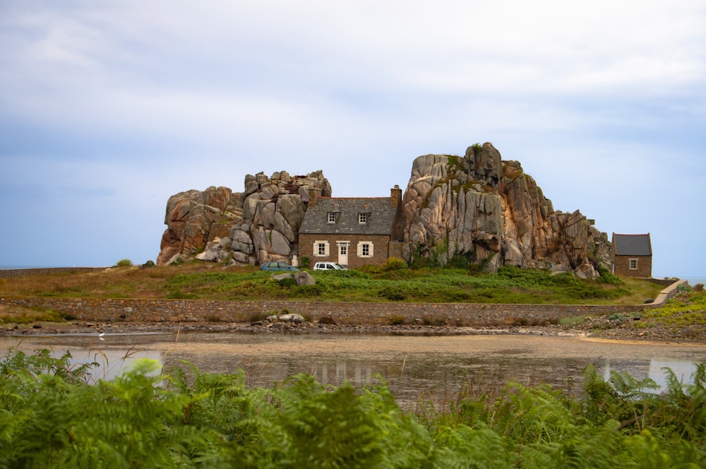 brown concrete house in between rock formation during daytime