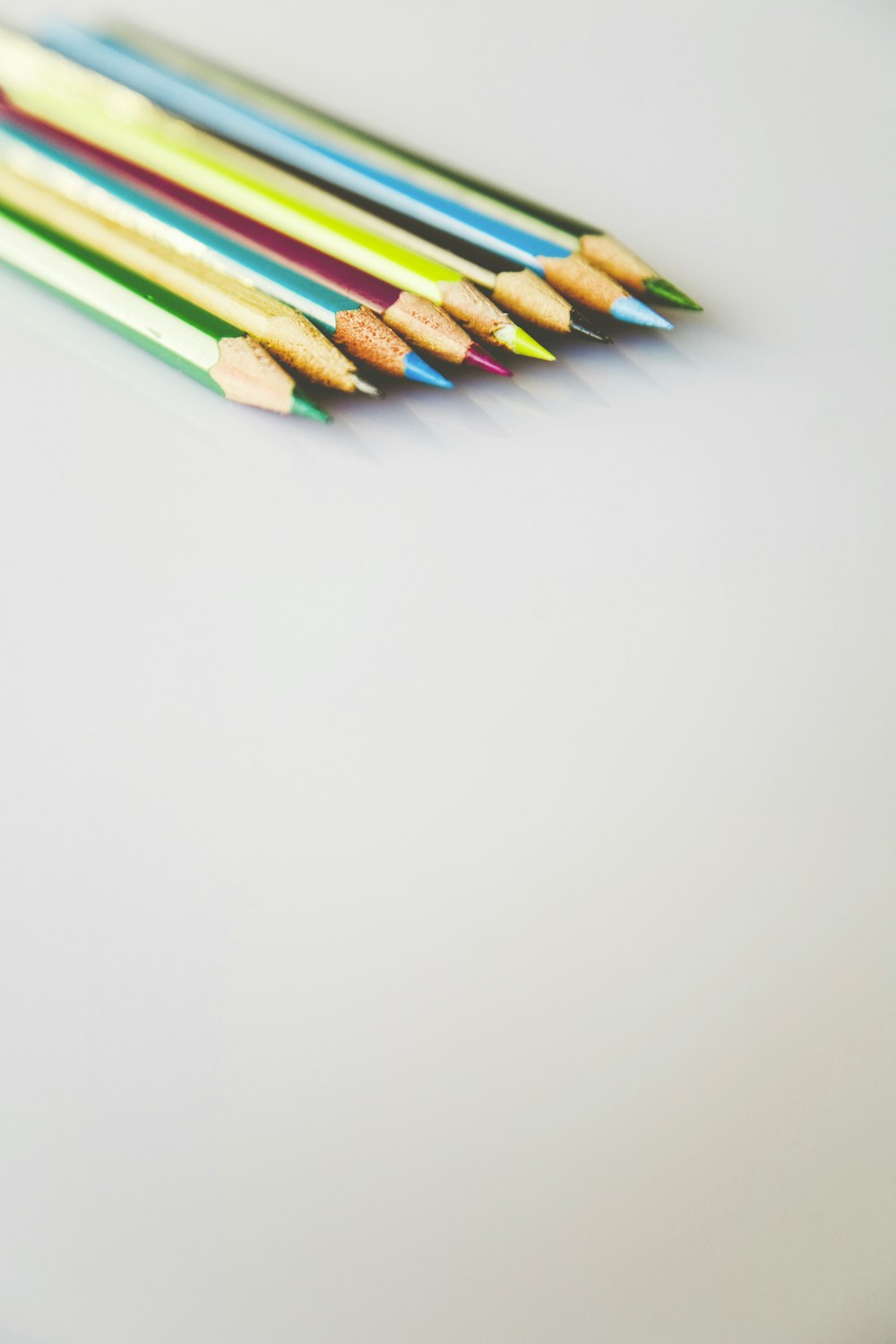 selective focus photography of assorted-color pencils on white surface