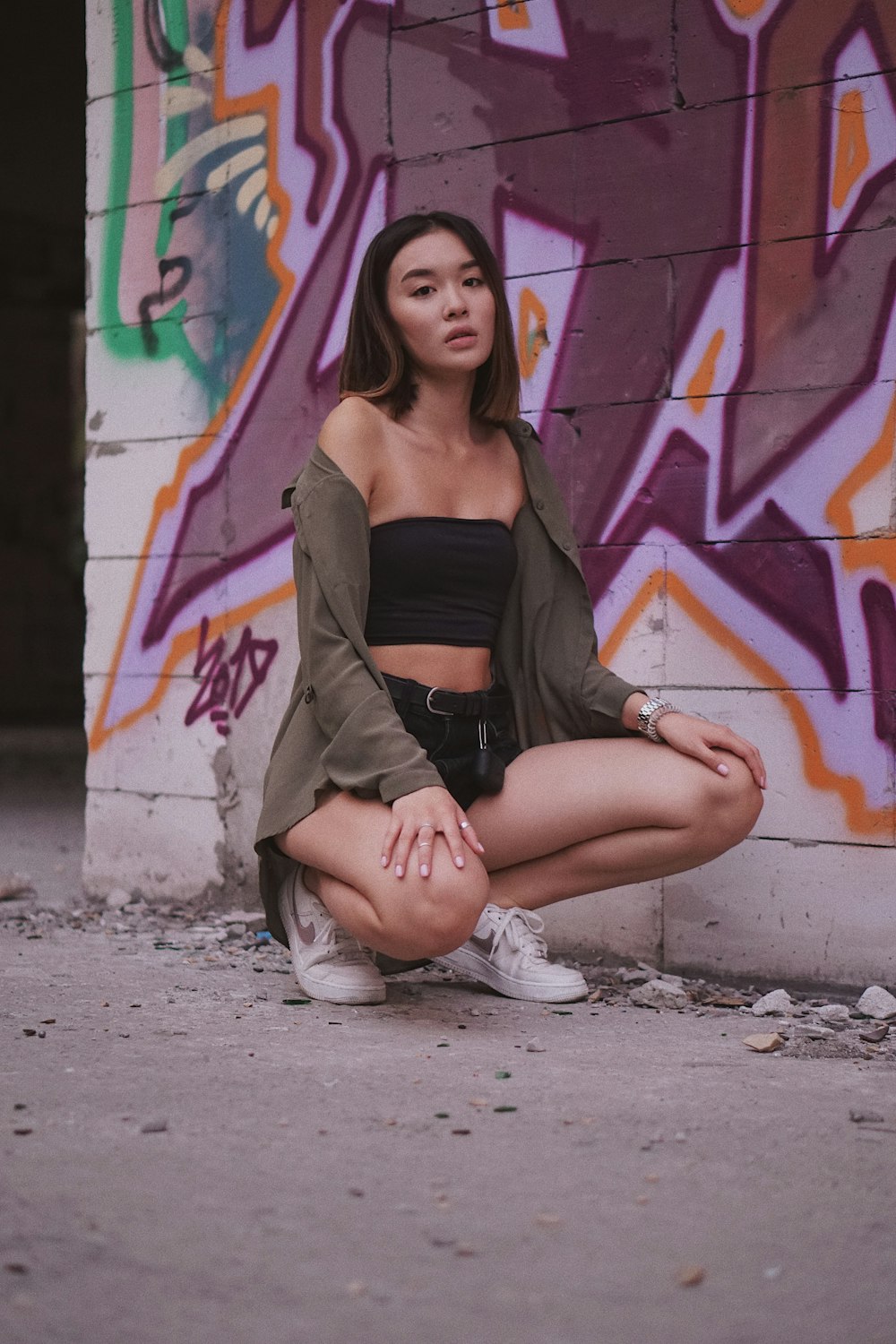 woman sitting near graffiti wall
