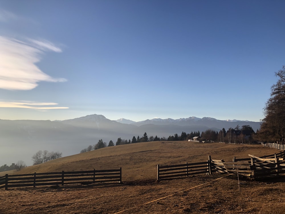 wooden fence on hill under blue sky