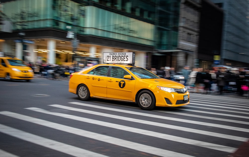 táxi amarelo na faixa de pedestres durante o dia