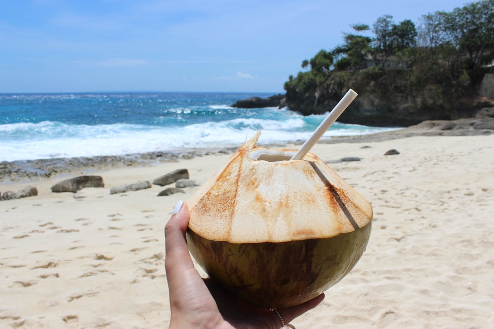 Persona sosteniendo jugo de coco