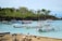 A turquoise lagoon with traditional boats gently floating near a Mayotte island shore.
