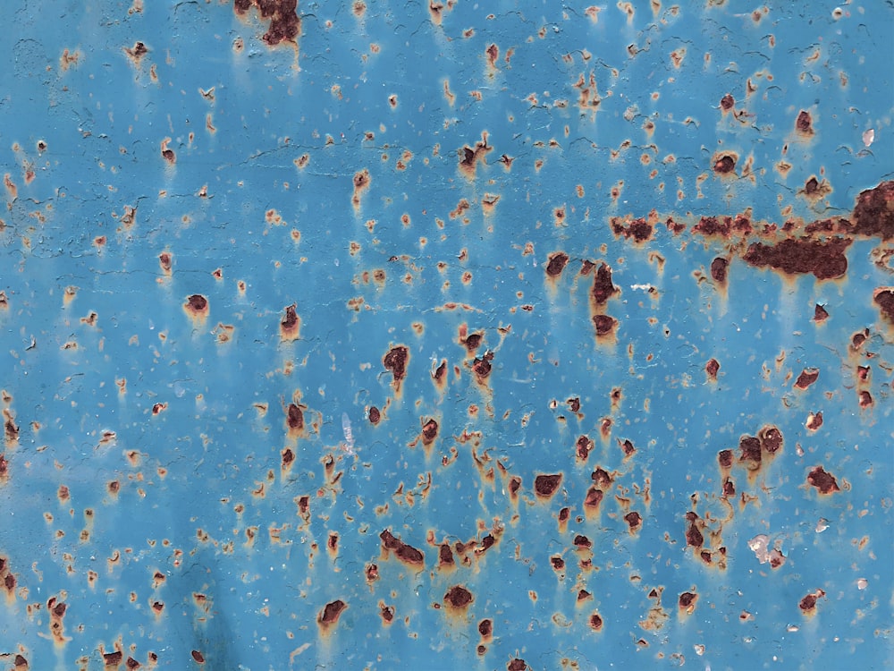a rusted metal surface with a blue sky in the background