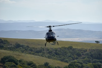black helicopter flying during daytime