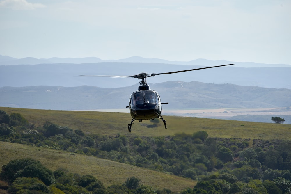 black helicopter flying during daytime
