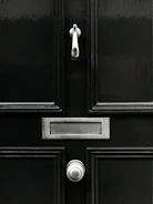 A sleek modern front door with a matte black finish and frosted glass panels.
