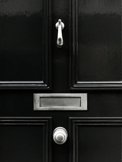 Sleek modern steel security door with matte black finish and brushed steel accents in a contemporary home entrance