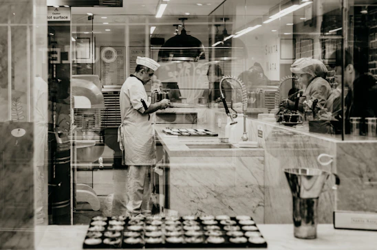 Portrait of a professional pastry chef in a kitchen surrounded by baking tools and ingredients.