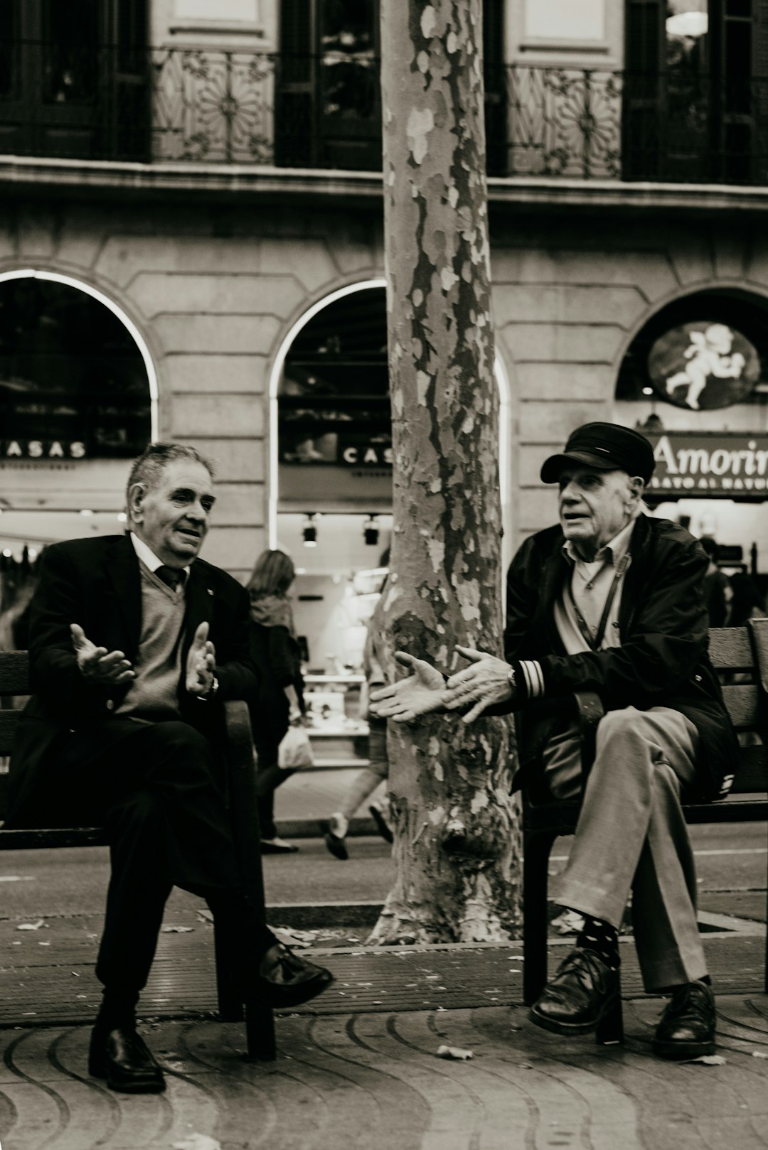 man and woman sitting on bench near building