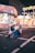 woman sitting beside 8 Town stall