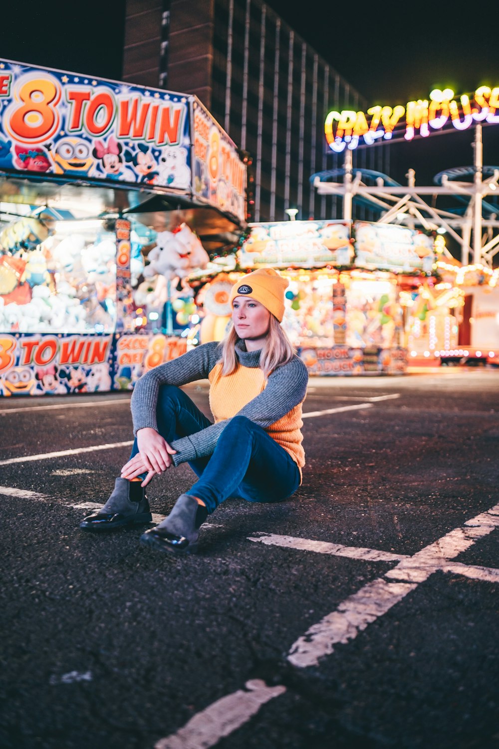 woman sitting beside 8 Town stall