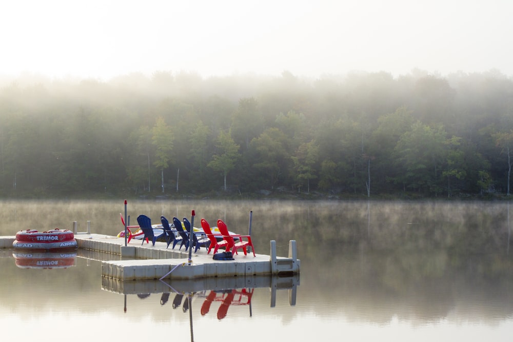 red and blue adirondack chairs on wooden dock during daytime