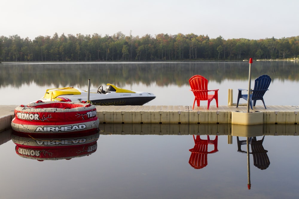 blue and red armchairs on dock bridge near lake