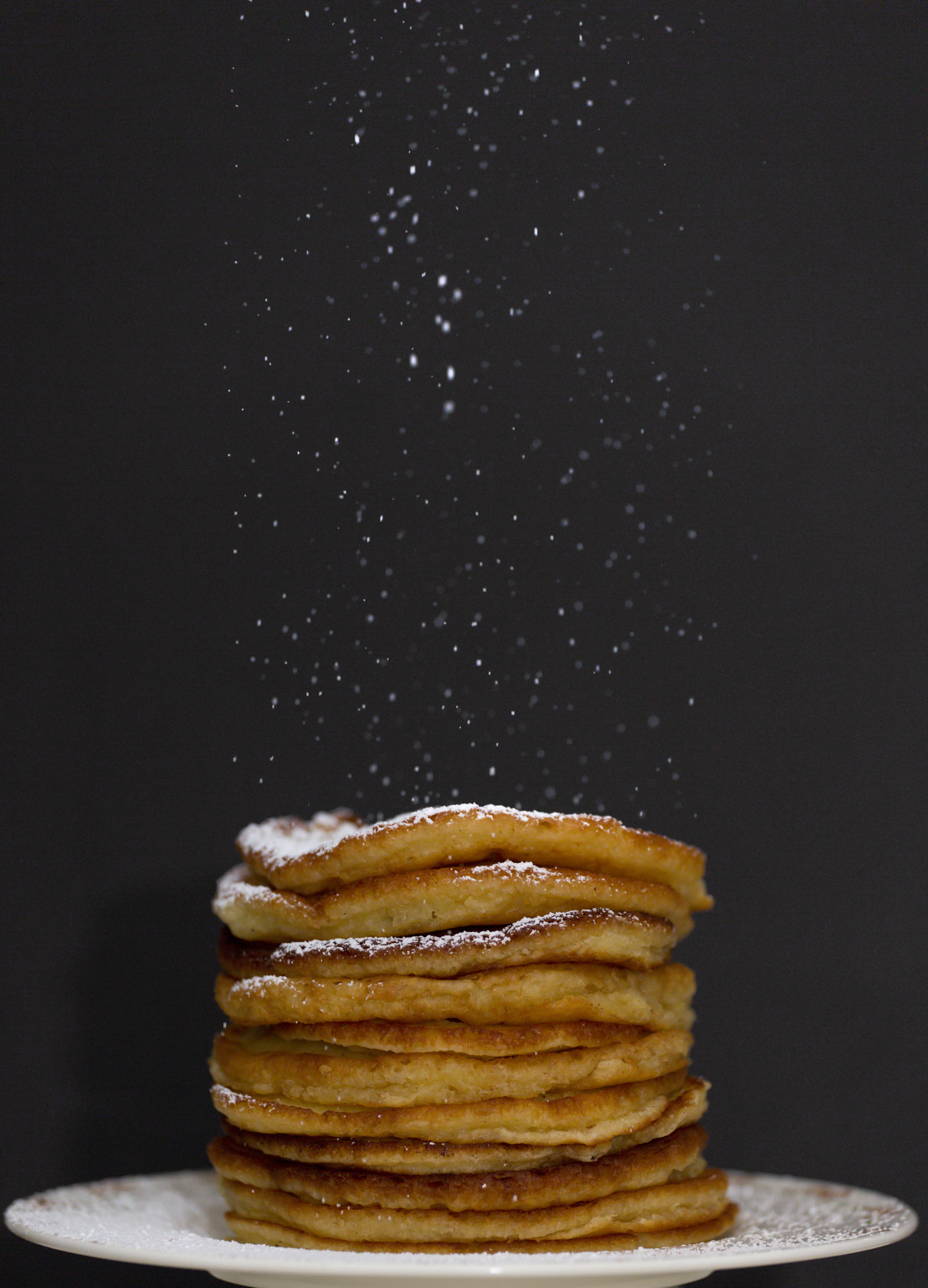 a stack of pancakes covered in powdered sugar