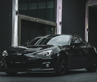 a black sports car parked in front of a building