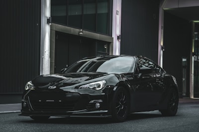 a black sports car parked in front of a building