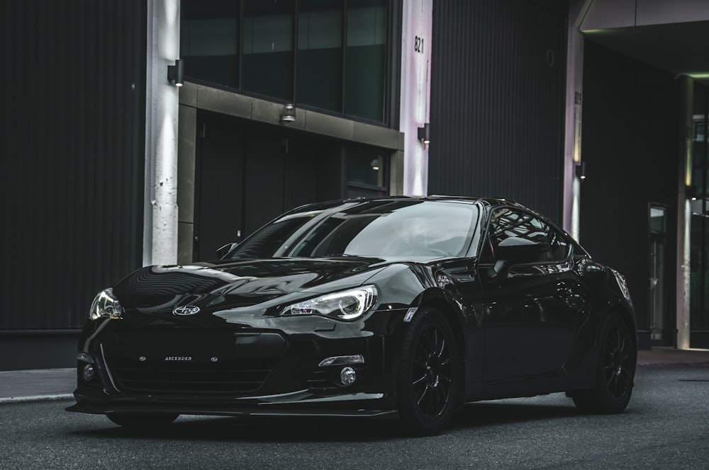 a black sports car parked in front of a building