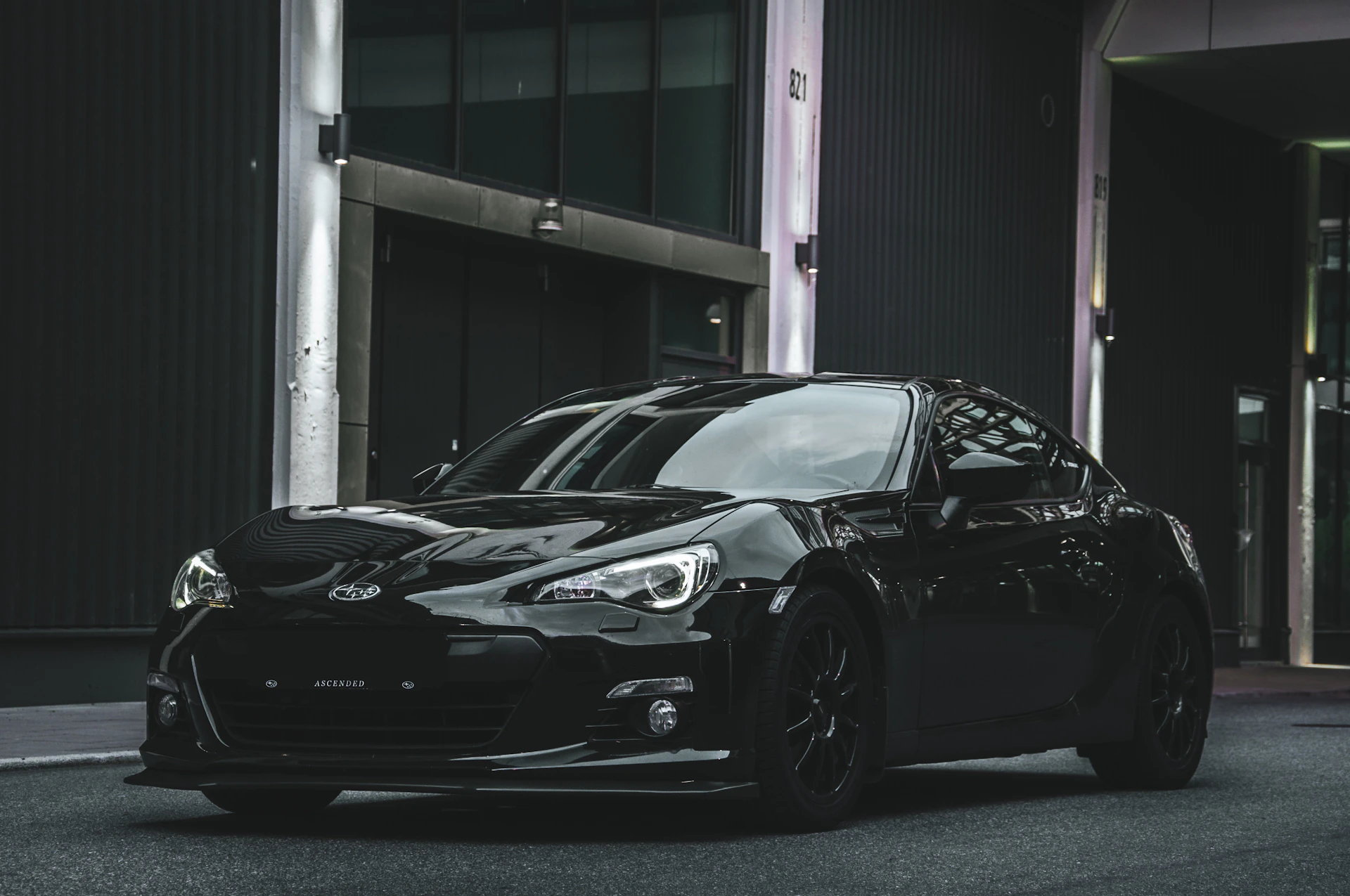 a black sports car parked in front of a building