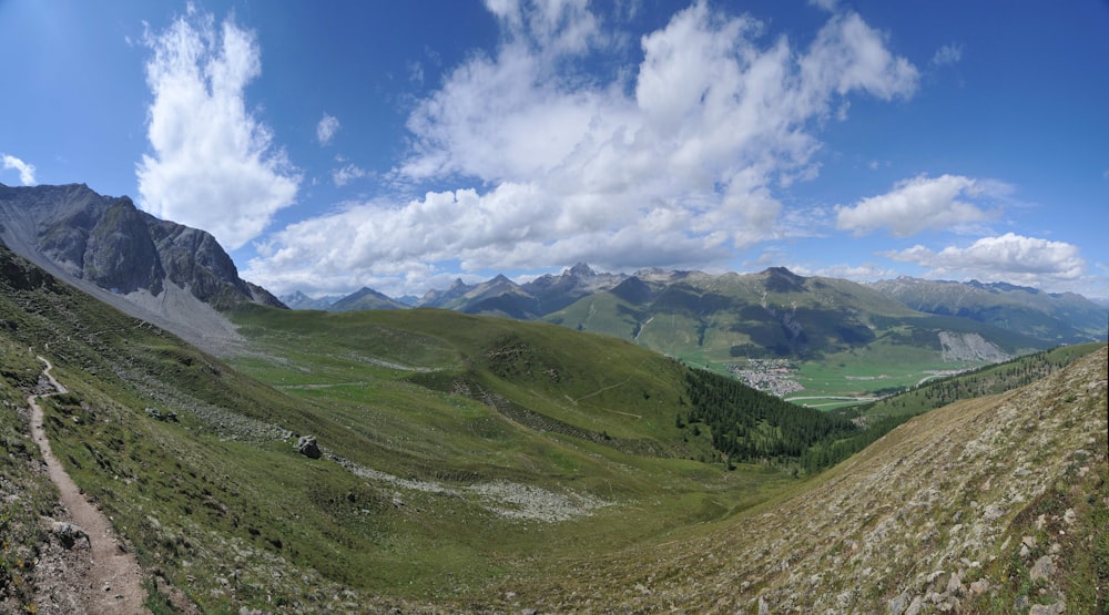 a scenic view of a valley with mountains in the background