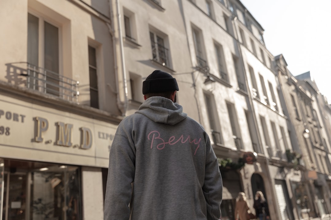 man wearing gray pullover walking on street